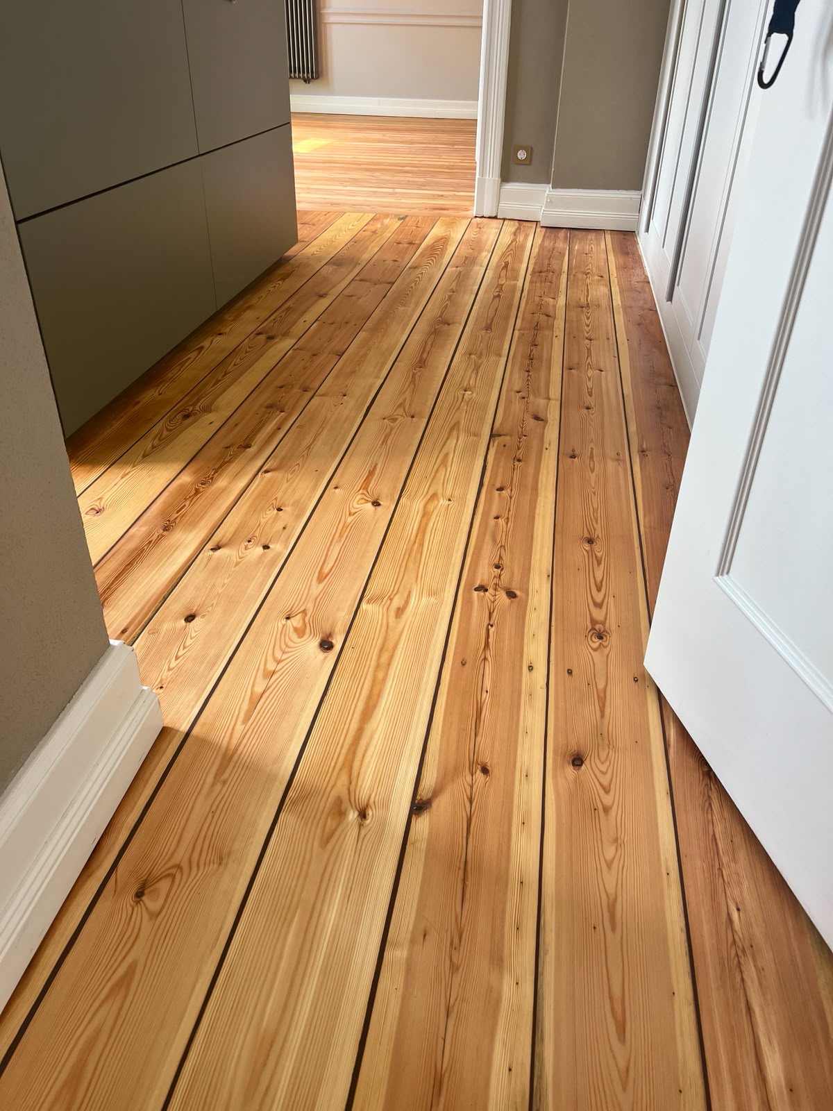 Frisch geschliffener und geölter Holzdielenboden in einem hellen Flur